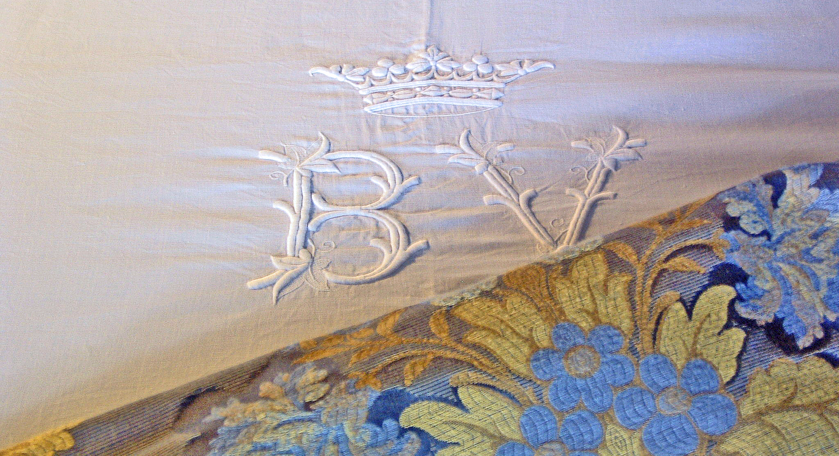 embroidered sheets with family crest in bedrooms